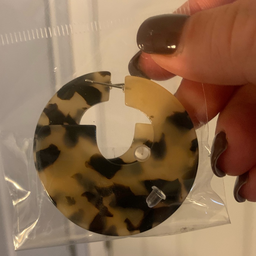 Pair of tortoise color statement earrings with clear backs, new in bag.